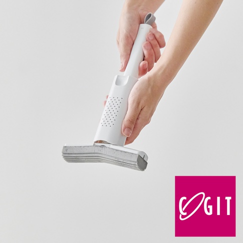 一雙手正握持一個白色推拉式海綿刷，刷頭為灰色多層海綿，帶有通風孔的白色手柄，背景為淺灰色。