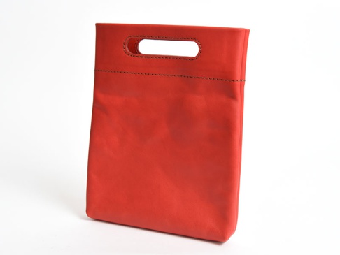 紅色皮革製直式收納袋中袋，頂部有長方形開口提把，袋身正面有兩條縫線裝飾。