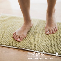 黃色棉麻混紡人字紋浴墊，觸感柔軟，有良好的吸水性，適合浴室使用。
