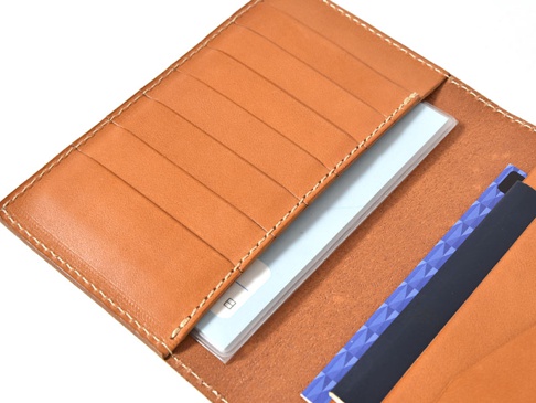 職人手作皮革多用途收納長夾 (KB-5)，展示了淺棕色皮革的內裡，包含多個卡槽，並置入一本淺藍色封面文件和兩張卡片，其中一張卡片有紫色幾何圖案。