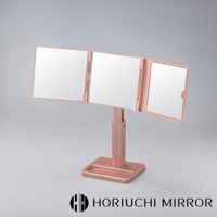 玫瑰金色的 NAPURE 桌上型三折化妝鏡，由三片方形鏡面組成，可旋轉調整角度，鏡架為金屬材質，帶有可調節高度的支架和方形底座。