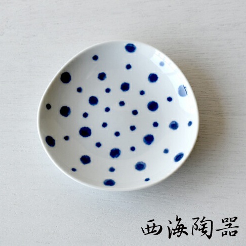 白色陶瓷醬料碟，佈滿藍色不規則圓點紋飾，碟面略有凹陷，適合盛裝醬料。