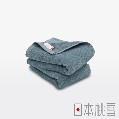 今治柔絨細膩快乾吸水毛巾，展示的是一疊兩件組的毛巾，呈現灰藍色調，材質觸感細膩，毛圈蓬鬆，頂部毛巾上可見品牌標籤。