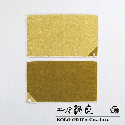 兩條棉麻混紡浴墊，上方為亮黃色，下方為芥末黃，均帶有白色滾邊，材質呈現細緻絨毛感。