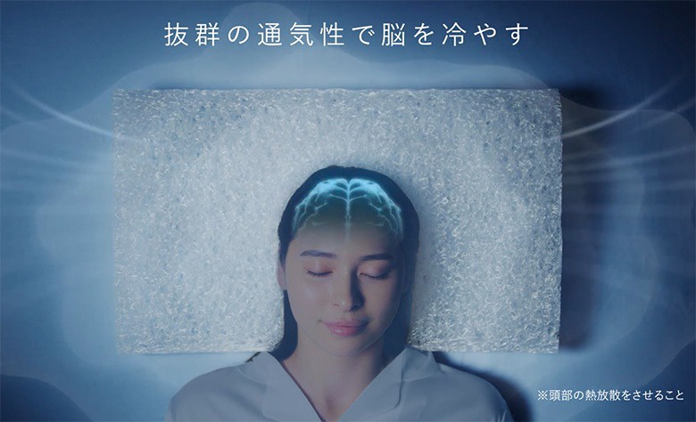 一名女子躺在一個白色、網狀結構的枕頭上，枕頭上方疊加了藍色的腦部影像，強調其透氣散熱的特性。