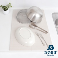NANOLABO 品牌 logo 旁顯示日文「なのらぼ」及英文「NanoLabo」，圖片為廚房一景，展示一個橢圓形白色盤子，兩個不鏽鋼夾子，兩個叉子，一個不鏽鋼濾網盆，以及一個不鏽鋼碗，皆放置於淺米色波浪紋的吸水墊上。