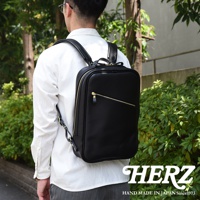 職人手作黑色皮革長方型多口袋後背包，配有金色拉鍊和品牌標誌。