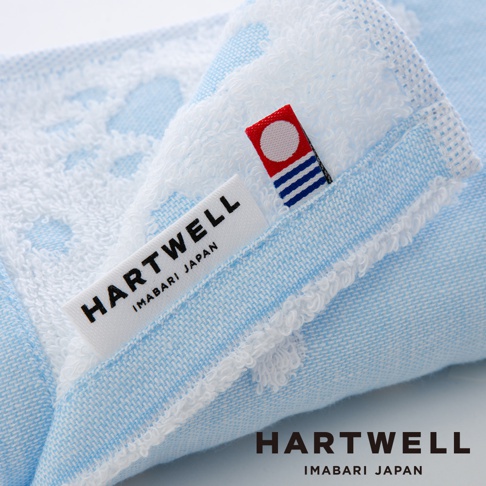 淺藍色今治純棉點點紗布毛巾，織有白色點點圖案，毛巾帶有 HARTWELL IMABARI JAPAN 品牌標籤及紅色旗幟標誌。