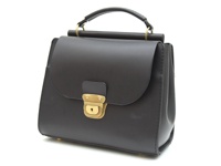 深棕色皮革手提包，具有翻蓋設計，配有金色鎖扣和鑰匙孔，頂部設有單提把，包身線條簡潔，風格復古。