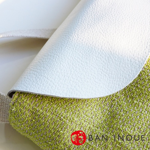 BAN INOUE 蚊帳棉裂織手提袋，白色皮革翻蓋搭配綠色紋理布料，側邊可見織帶。