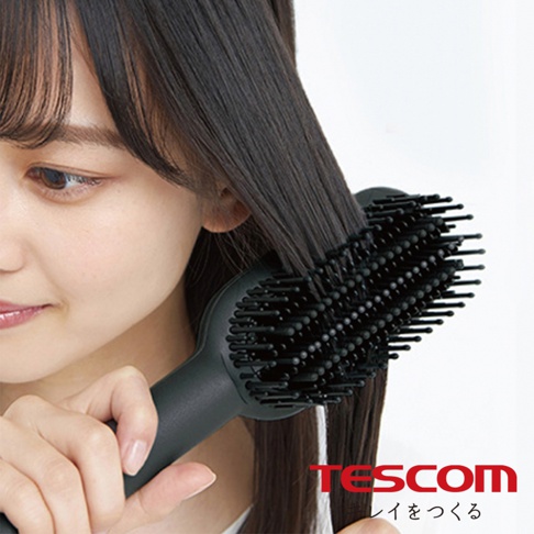 一位女性正在使用黑色負離子直髮造型梳整理她的長髮，梳子上有許多細密的梳齒。