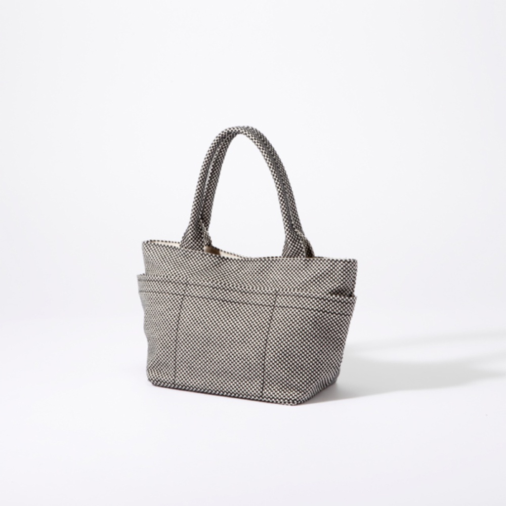 三河木綿刺子織手提托特包，黑色與白色網格圖案，帶有兩個提把和外部口袋。