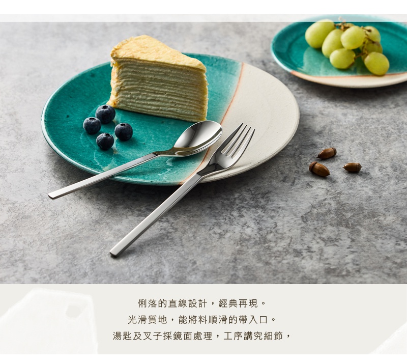 簡約直線設計的不鏽鋼湯匙與叉子，擺放在有藍色點綴的盤子上，旁邊還有蛋糕和藍莓。