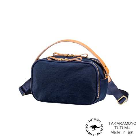 TUTUMU Rectangle 兩用斜背包，以深藍色防潑水材質製成，搭配皮革提把和品牌標誌，展現日系簡約風格。