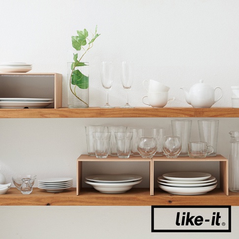 木紋雙層整理架，上方擺放著玻璃杯、白色茶壺與疊放的白色杯子，下方則有木紋隔板，隔板上放置白色盤子與玻璃杯。