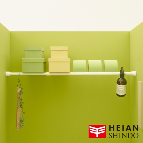 白色獨立腳升級版防掉落置物架，架上擺放著淺綠色與淺黃色紙盒、淺綠色捲筒衛生紙，以及一個棕色噴瓶。