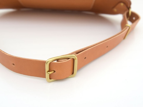 職人手作皮革拉鍊旅行斜背包 (F-7)，展示了淺棕色皮革材質和黃銅色金屬扣環，可調節的皮革背帶細節。