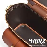 HERZ 品牌標誌與手工製造標語，展現職人手作皮革厚實相機包的精緻細節