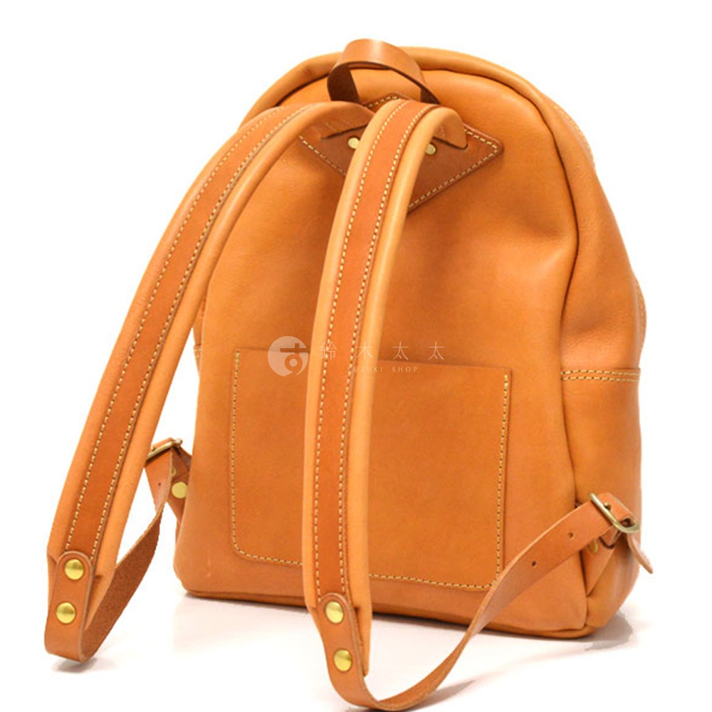 職人手作皮革休閒風後背包 R-93，焦糖棕色，具有兩個肩帶，背包背面有一個方形口袋，整體為圓潤造型，材質為皮革。