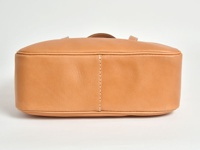 淺棕色皮革托特包，側面有精緻縫線裝飾，包身線條圓潤，採用簡約設計。