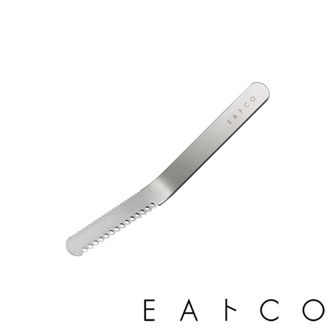 銀色不鏽鋼奶油刀，刀刃一側有鋸齒狀邊緣，另一側有小圓孔，刀柄上方印有「EATCO」字樣。