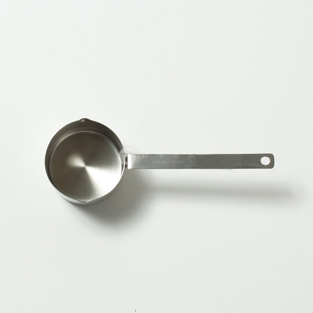 不鏽鋼雙口長柄計量杯，銀色，圓形杯身，一體成型長柄，柄末端有掛孔，材質為不鏽鋼。