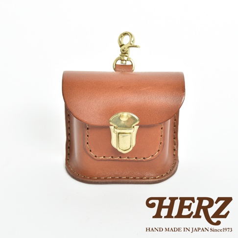 棕色皮革製成的耳機收納包，設有金屬扣環和掛繩，設計簡約，適合日常攜帶。