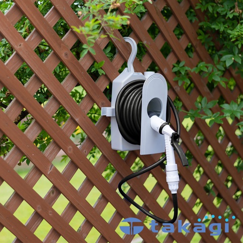 灰白色壁掛式水管收納架，裝有黑色水管，架上附有白色和黑色噴嘴。