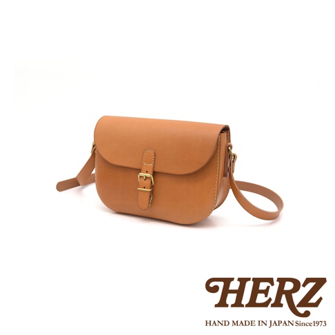 職人手作皮革經典馬鞍包 CK-7 S，採用淺棕色皮革製作，設有金屬扣環和可調節肩帶，側邊有縫線細節。