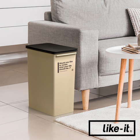 淺米色掀蓋式高版垃圾桶，配有黑色掀蓋，側面有英文標語。