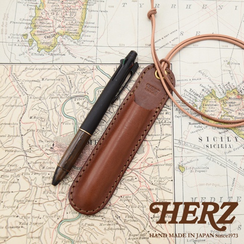 職人手作皮革掛繩筆套KP-3，搭配一支多色筆，置於地圖背景上。