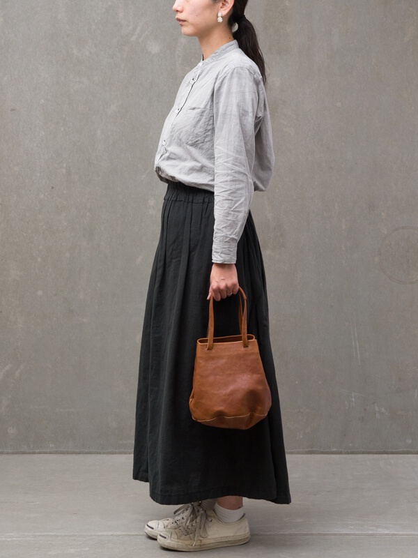 職人手作皮革Organ抽繩肩背手提托特包 (G-84) S，此款包包為棕褐色皮革製成，造型簡約，擁有短提把，展現皮革自然的紋理與質感，適合搭配休閒服飾。