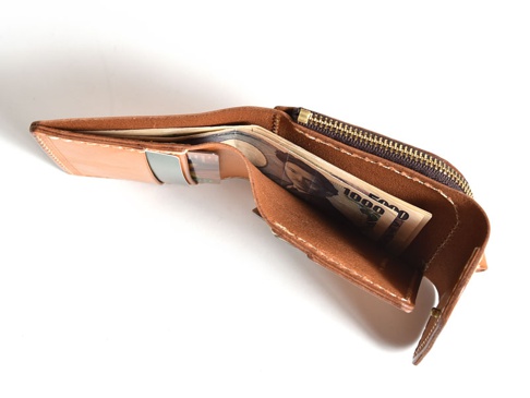 職人手作皮革短夾，淺棕色皮革，內含日圓鈔票，銀色金屬夾，拉鍊開合。