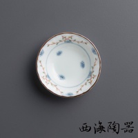 白色陶瓷小碟，邊緣飾有棕色釉，碟身內側繪有淡藍色小花和綠色藤蔓圖案，呈現日式風格。