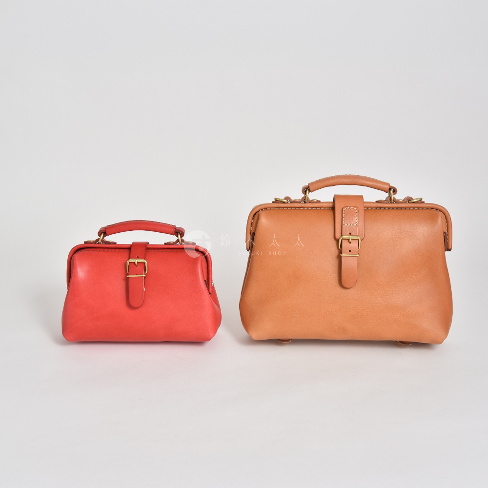 一紅一棕兩個皮革醫生包，中間有金屬扣環與皮帶設計，皆有手提把，風格簡約。
