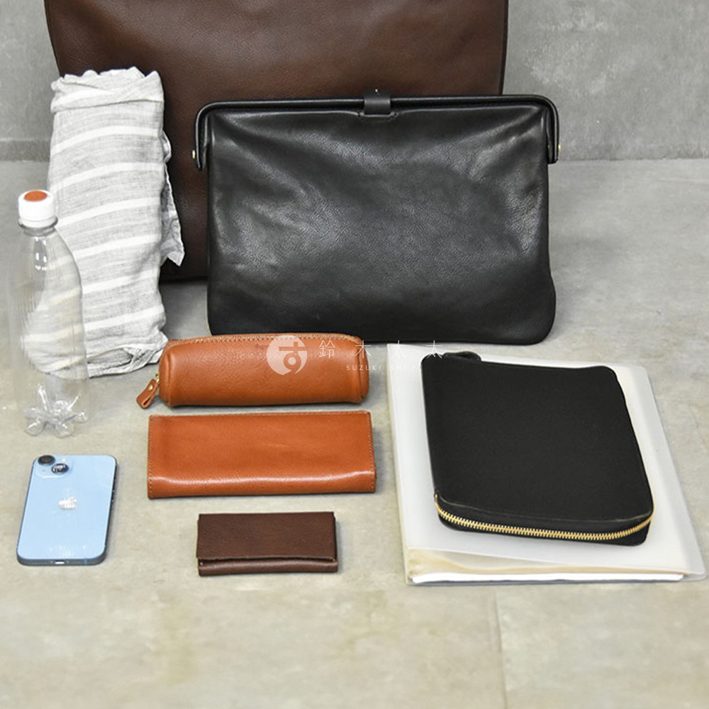 多個皮革製品，包含黑色手提包、化妝包、長夾、零錢包、手機及水瓶