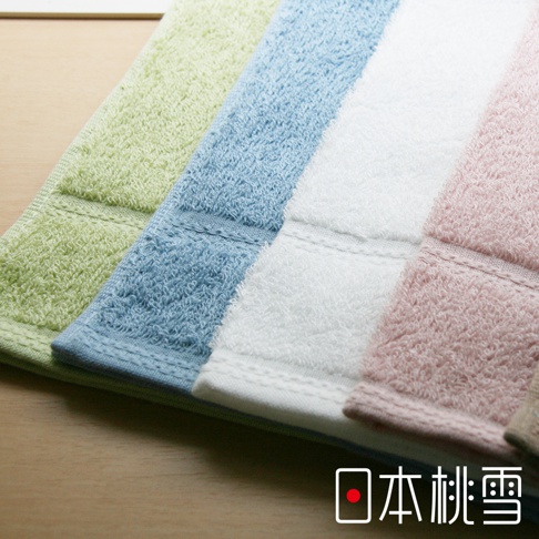 四條居家毛巾，由左至右分別為淺綠、淡藍、白色和粉紅色。毛巾表面有明顯的毛圈織紋，質地蓬鬆，邊緣有縫線裝飾。