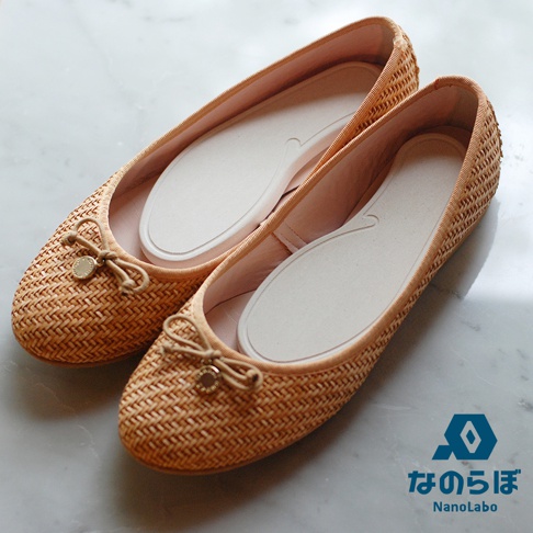 兩雙米色編織平底鞋，鞋頭有蝴蝶結和金色吊飾，內有白色鞋墊，背景是淺色大理石紋。