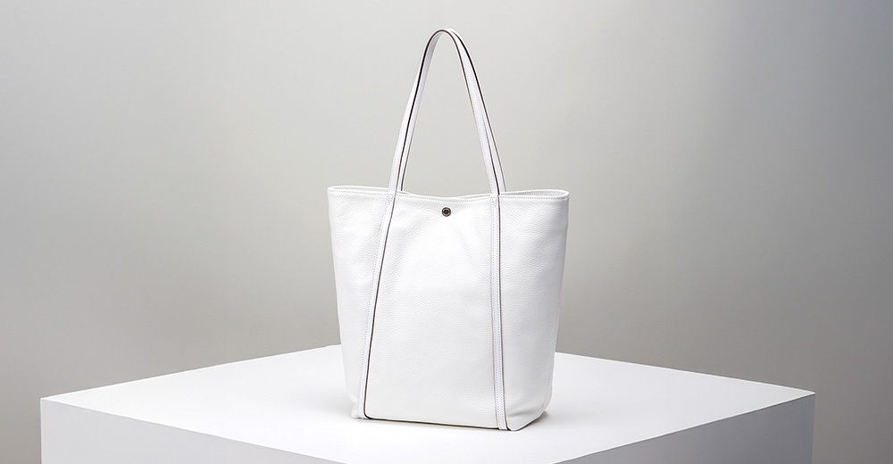 JETTER 大容量白色皮革托特包，具有雙肩帶和單顆銀色金屬釦開合。包包表面有細緻的顆粒紋理，側面有縫線裝飾。
