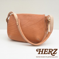 棕色皮革郵差包，具有獨特的紋理和縫線細節，搭配淺色皮革的肩帶和金屬扣環。