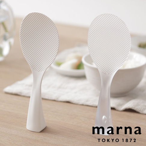 marna TOKYO 1872 品牌 logo 旁展示兩個白色站立式飯匙，左側飯匙置於左前方，右側飯匙置於右後方，飯匙表面有顆粒紋路，下方碗內裝有米飯