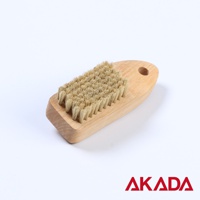 天然豬毛製成的塊莖蔬果刷，刷毛呈淺棕色，刷柄為光滑的淺木色，帶有圓形掛孔。