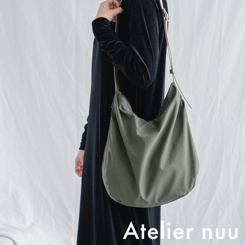 Atelier nuu ssent 肩背托特包，展示女性側身穿著黑色長洋裝，並搭配軍綠色柔軟皺褶肩背包。