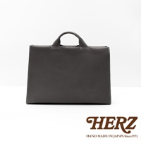 日本HERZ手工皮革簡約商務公事包，採用深灰色皮革製成，中間有白色縫線和手提帶。
