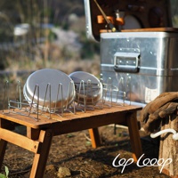 一個木製折疊桌上擺放著兩個不鏽鋼鍋，上方有金屬瀝水架。旁邊是露營箱和一雙皮革手套。