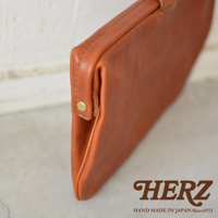 職人手作皮革Organ手拿包，呈現溫潤的棕褐色，簡約的設計搭配金屬按扣，材質為天然皮革。