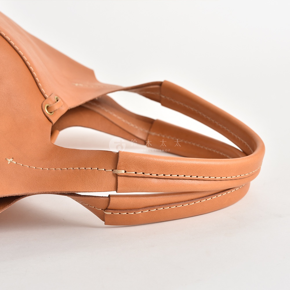 職人手作皮革球形肩掛托特包 Q-3，使用淺棕色皮革製作，有著精緻的縫線細節，展現其簡約的設計風格。