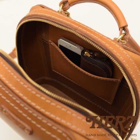 職人手作淺棕色皮革立體商務後背包，內部有一個手機和一個拉鍊零錢包。