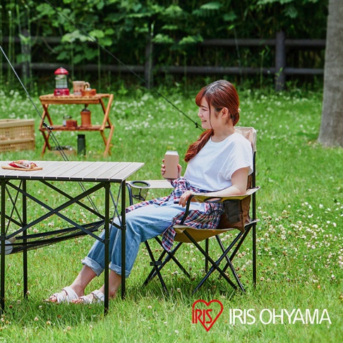 露營摺疊野餐椅，高款，米色布料，黑色金屬骨架，附有側邊置物網袋和杯架。椅背綁有格紋襯衫。