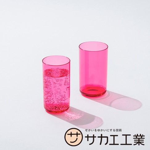 SAKAE 品牌標誌旁有兩個粉紅色玻璃杯，其中一個杯子裝有氣泡水